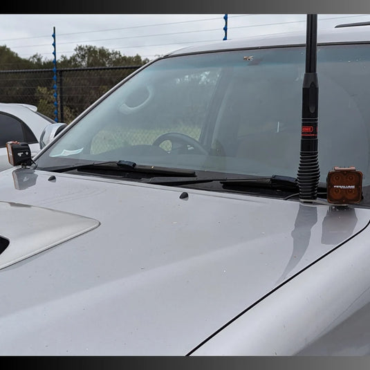 Close-up of Scrub King ditch light bracket mounted to Hilux N70 bonnet hinge – no drill required